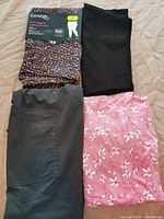 Photo of four pairs of women's bottoms - black leggings with leopard print packaging, black spandex shorts, dark gray pajama pants with pocket, pink floral pajama pants.