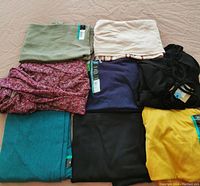 Eight folded women's 4XL tops in various colors, some tagged