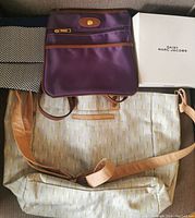 Photo showing purple crossbody bag, Daisy Marc Jacobs tote, black and white patterned cosmetic bag and orange pouch