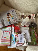 Photo of assorted winter and holiday-themed baking bags with clear plastic chocolate molds and decorating bottles on beige background