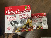 Photo showing box of Betty Crocker Heavy Duty Burner Liners Large 8 inch (6 count) and Small 6.5 inch (10 count)