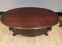 Top view of the oval wooden coffee table showing smooth wood grain finish and rounded edges.