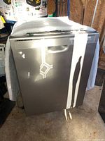 Front view of Whirlpool dishwasher with silver spray-painted front panel and handle.