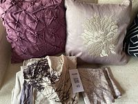 Photo showing duvet cover fabric and two decorative throw pillows on a light surface