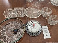 Top-down photo showing three glass platters, cream and sugar set with metal holder, glass dish with cover, and serving spoon.