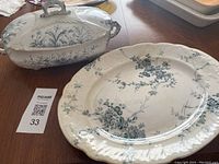 Photo showing oval serving platter and covered serving dish with blue floral pattern and crazing on ceramic surface.