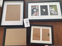 Four picture frames displayed on table: one multi-opening frame, one large single-opening frame, one medium frame, and one two-photo frame.