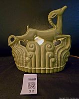 Front view of the green ceramic Art Deco style gazelle lamp with detailed motifs and working cord visible