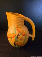 Photo of the west side of the ceramic pitcher showing decorative floral painting.
