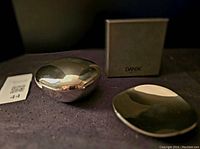 Photo showing both the lidded box and open dish together with the original box in the background on a dark surface.