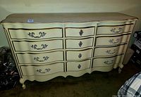 Full frontal view of the dresser showing the serpentine front curve and 12 drawers with ornate hardware.