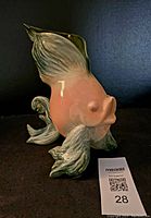 Side profile view of the angel fish-shaped ceramic vase highlighting the curved fins and peach body.