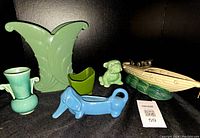 Overview of all 5 pottery pieces including boat planter, dachshund planter, bulldog figurine, green deco vase, and blue-green handled vase