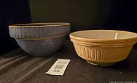Both blue salt glaze stoneware bowl by A.D. Ruckels and yellowware bowl side by side showing size and shape.