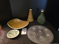 Photo of the lot showing the Kosta Boda oyster plate, mustard yellow ceramic dish, two vases, and small blue and white ceramic dish.