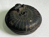 Top view of the antique copper water dropper showing chrysanthemum petal design and frog figure near central hole.