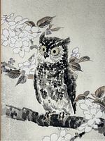 Close-up image showing the detailed woodblock print of an owl perched on a branch with cherry blossoms and leaves in muted colors.