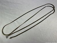 Full view of the sterling silver chain laid out flat, displaying its length and clasp