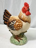 Full profile view of the ceramic rooster showing body, tail feathers, and base.
