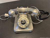 Front angled view of the vintage silver Crosley rotary dial phone showing scratches and wear on the handset and base.