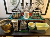 Overview image showing all garden decor items including terrariums, ceramic planters, brass planter, and metal pineapple containers arranged on a table