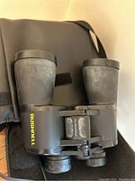 Close up of Bushnell binoculars showing brand and lens caps