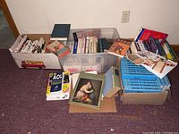 Image of multiple boxes and containers full of cookbooks, health books, and an encyclopedia set, assorted sizes and conditions visible