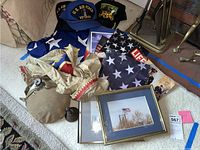 Wide view of the lot showing hats, flags, canteen, bell, framed photos, costume, and magazine