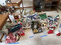 Full selection of vintage Christmas decorations spread on carpet including ornaments, figurines, wreaths, stockings, and additional holiday decor items