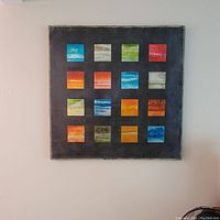 Full view of abstract oil on canvas depicting a black square background with 16 smaller colored squares in 4 rows and 4 columns.