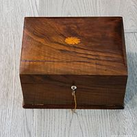 Top view of the antique wooden box showing natural wood grain and starburst inlay.