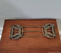 Top-down view of Art Nouveau brass book holder displaying intricate side panel design.