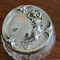 Close-up of sterling silver lid featuring Art Nouveau woman relief and 'STERLING' mark