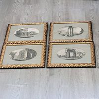Set of four antique black and white framed prints laid on floor depicting architectural landmarks