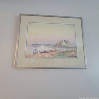 Framed watercolour hanging on a wall, showing the full artwork with boats, figures, and a distant structure on the water.