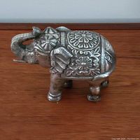 Left-side view of elephant figurine showing overall shape and decorative engraving.