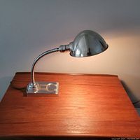 Photo of the vintage chrome table lamp powered on, showing light cast and chrome finish.
