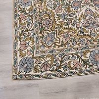 Close-up of the corner showing detailed floral border and texture of weave.