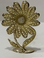 Full view of the heavy cast metal flower earring holder with perforated petals and textured center