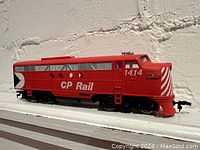 Left side view of the red CP Rail locomotive model with number 1414 and distinctive front stripes.