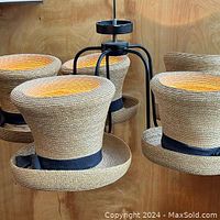 Close-up of the natural straw hat-shaped lamp shades with black grosgrain ribbon bows around the crown.