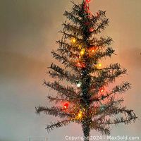 Full view of silver aluminum tree lit with original string lights
