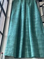 Curtain hanging showing full length and aqua/green/blue color blend with texture