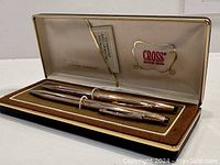Open Cross presentation box containing gold filled pen and pencil set on brown velvet interior