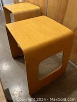 Front view of both nesting tables, showing curved U-shaped profile and honey oak laminate finish