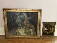 Both paintings displayed side by side against wall on floor showing relative size and condition