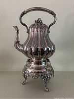 Full view of kettle on stand showing overall form and decoration