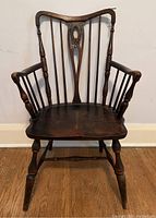 Full front view of Windsor chair showing contoured seat, armrests, turned spindles, and overall condition.