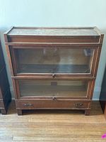 Front view of complete bookcase showing two glass-front cabinets and base drawer