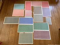 Multiple uncut press sheets laid out showing various colors and denominations on wood floor
